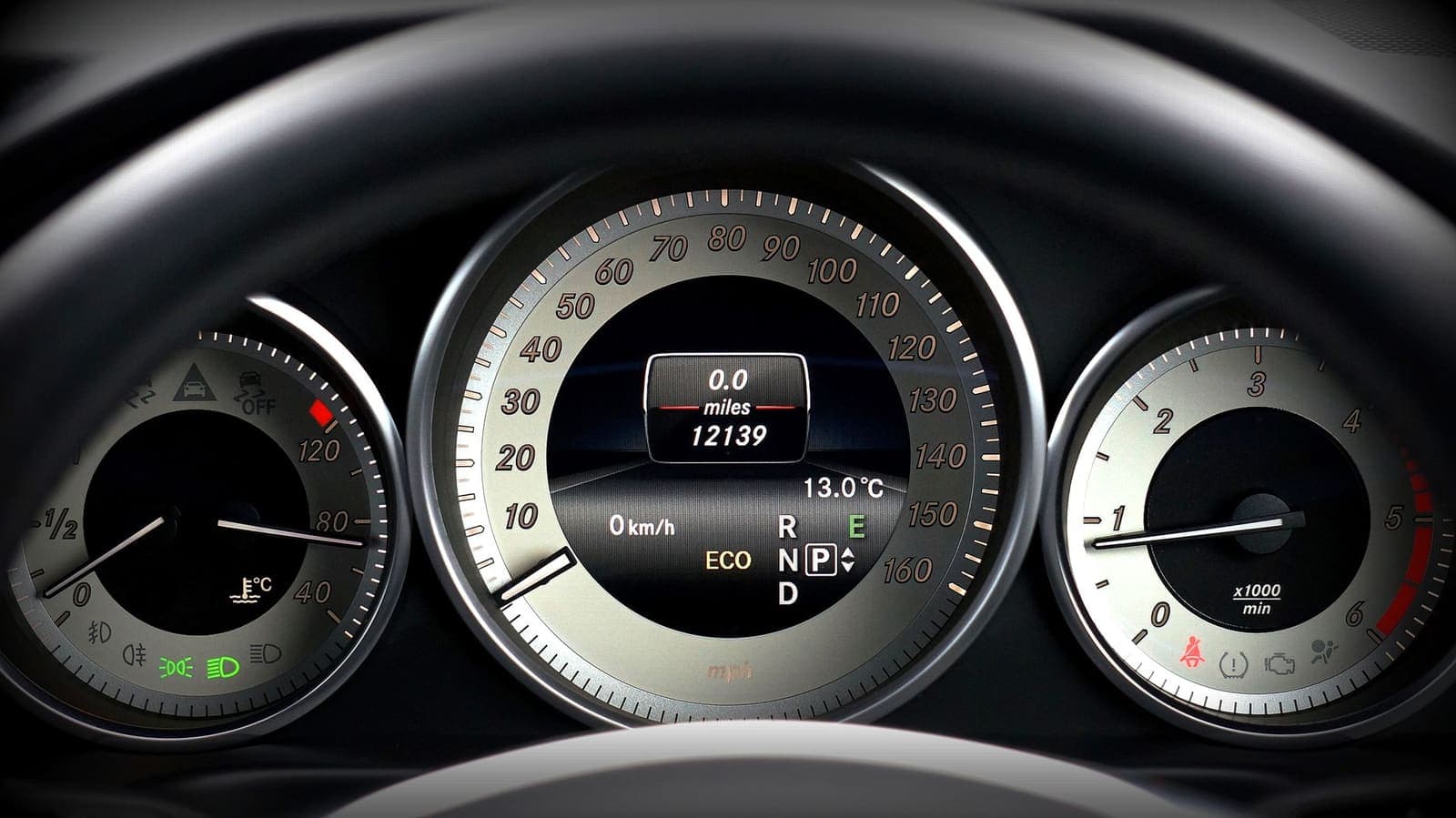A car instrument cluster showing the speedometer, tachometer and an odometer reading in miles