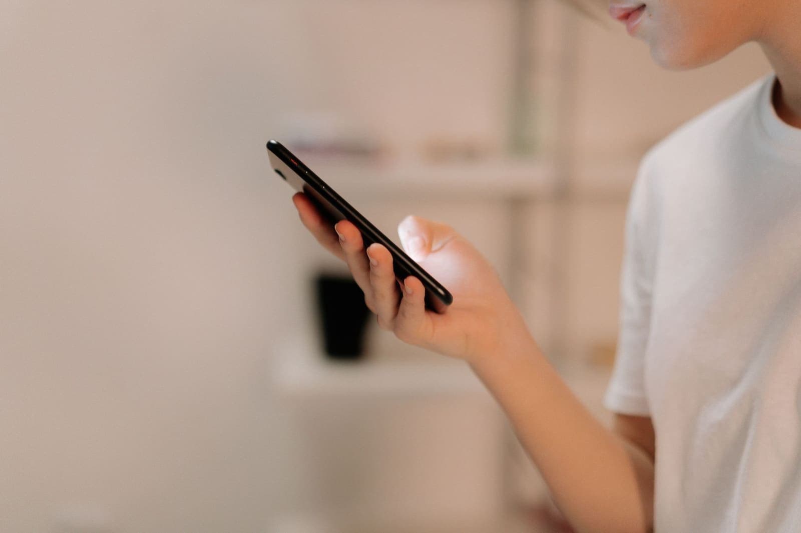 A person holds a smartphone in one hand and taps the screen with the other