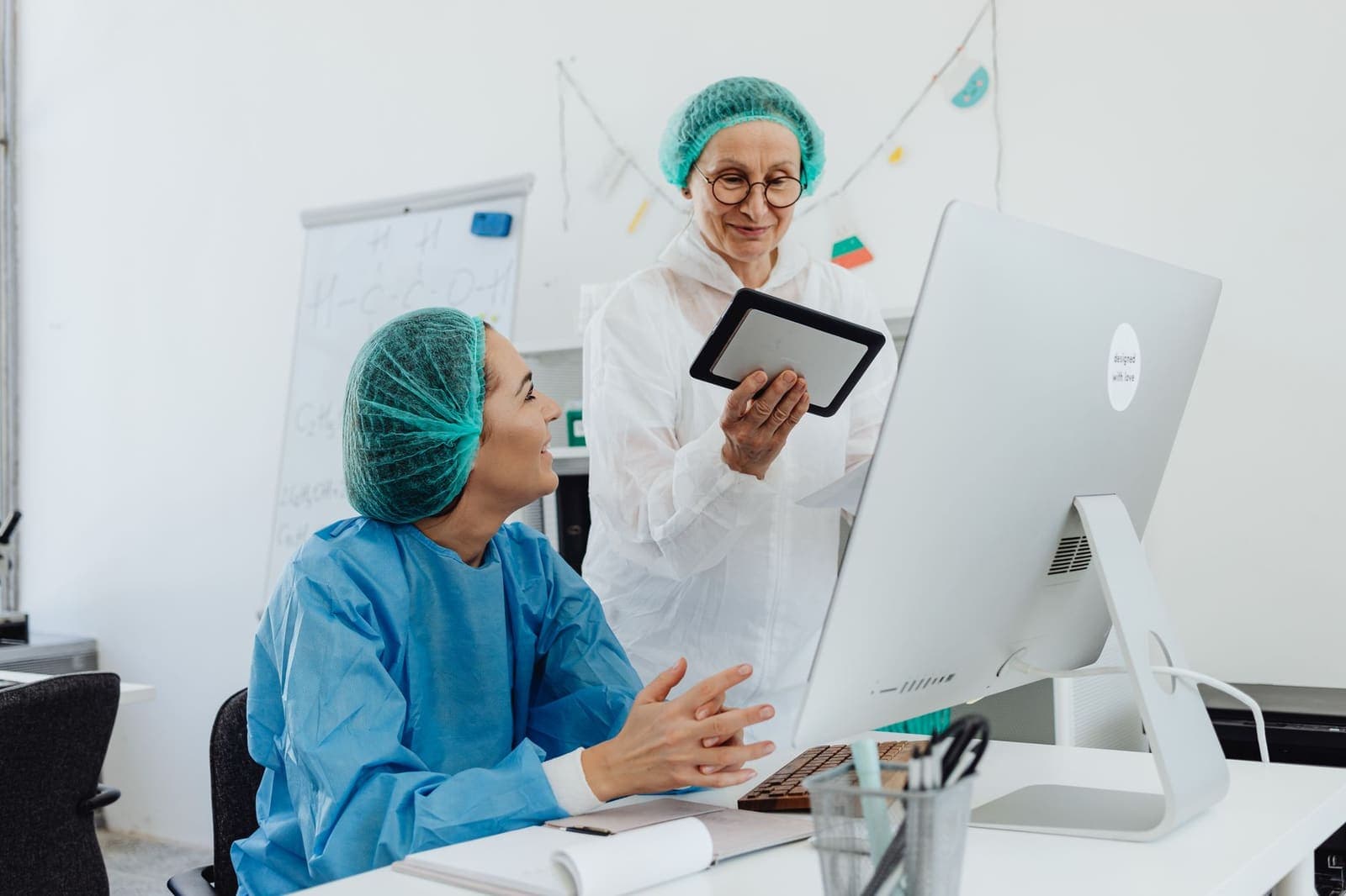 Two researchers discussing a study on a tablet in a laboratory