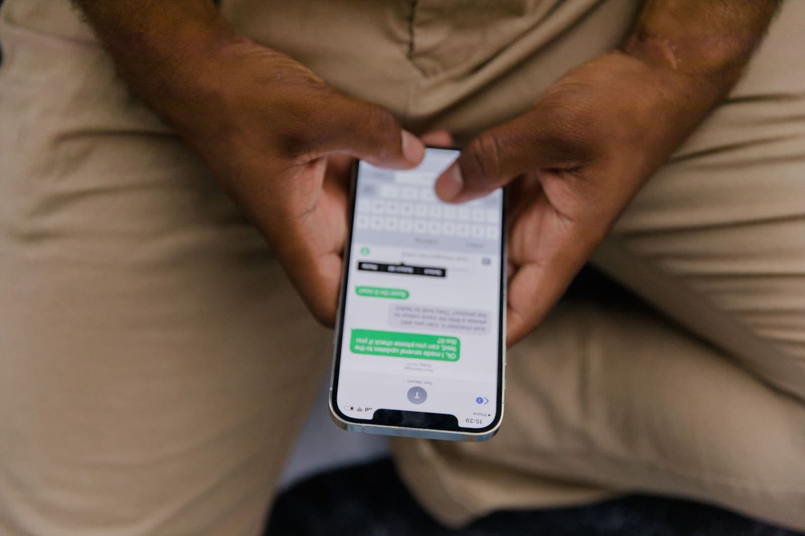 Hands holding a phone showing a text message conversation